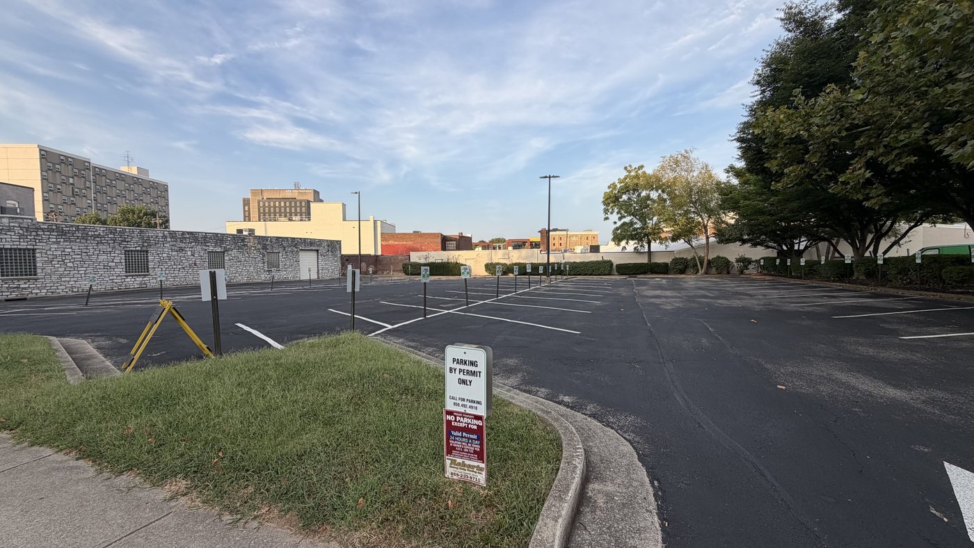 The lot entrance at 315 E High St, Lexington, with the permit sign on the post